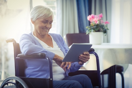 Senior in Wheelchair Reading Tablet