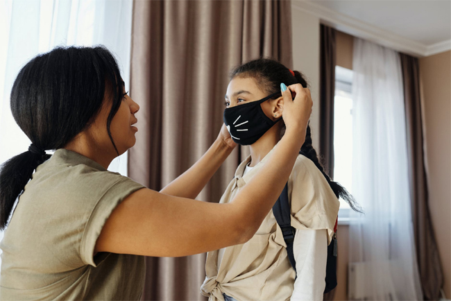 Mother Putting Mask on Child