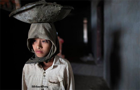 Young girl carrying cement for a new hotel in Burma